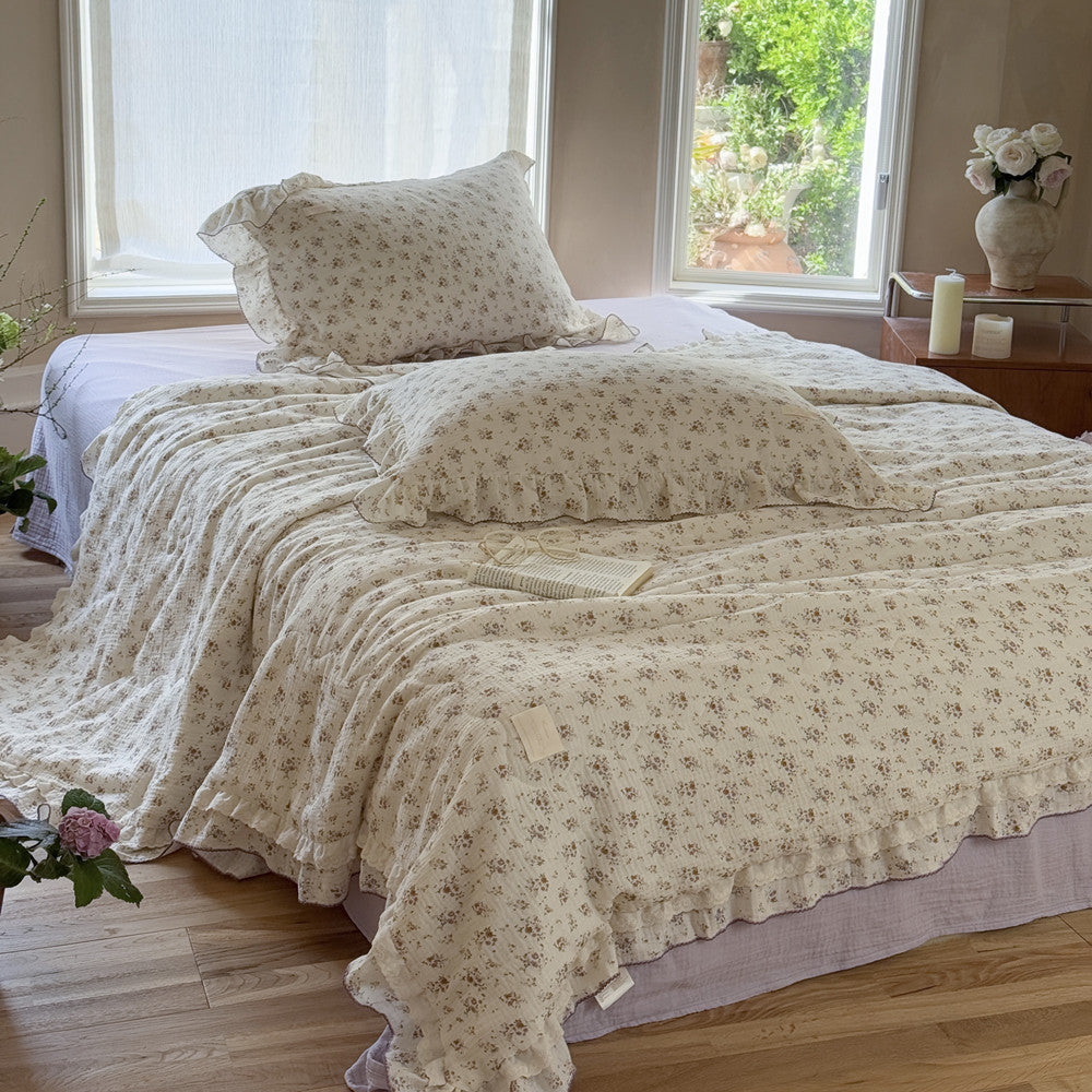 Romantic floral cotton comforter with lavender ruffles in vintage-style bedroom