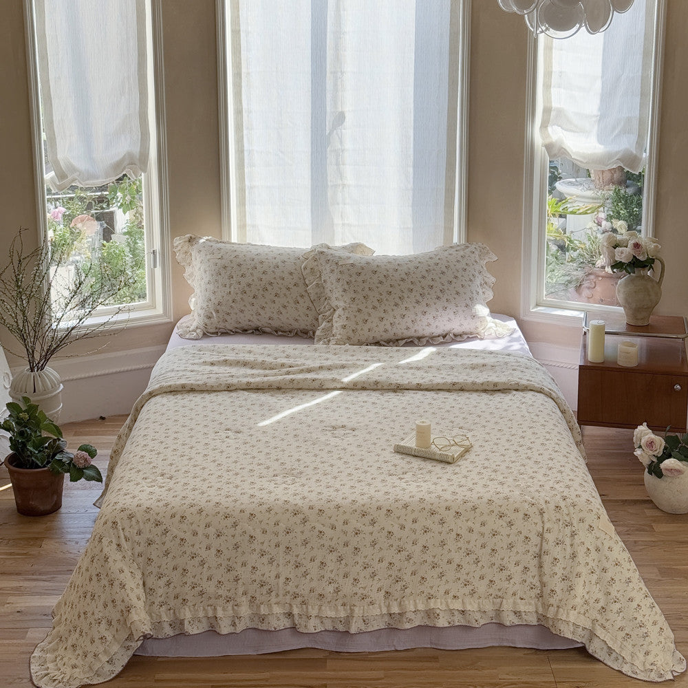 Elegant floral comforter styled on lavender gauze sheet with ruffled finish