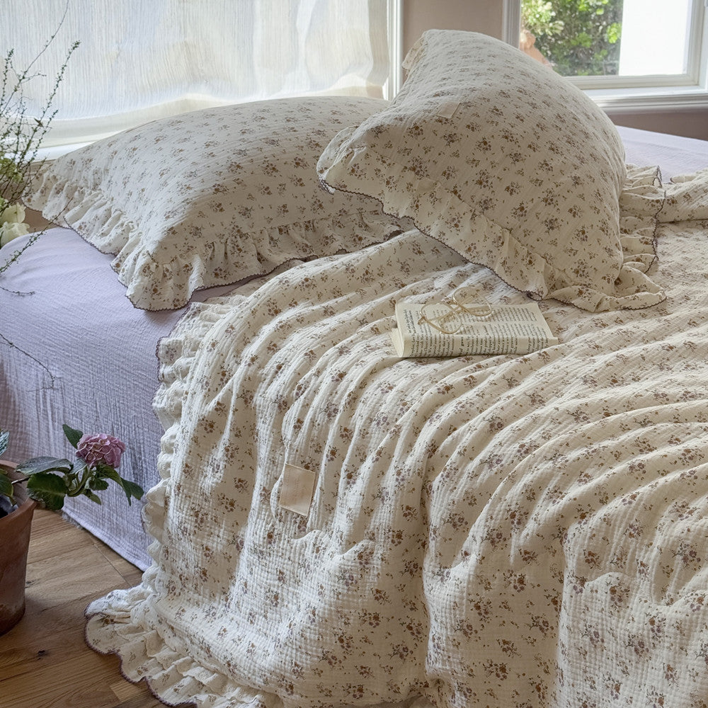 Breathable floral cotton comforter with lavender ruffled trim and cozy layered bed