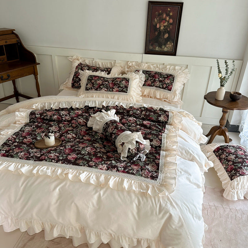 Full view of dark floral cotton bedding set with ruffled edges