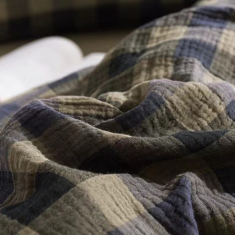 Close-up texture shot of the Army Green Plaid pattern on the gauze cotton bedding, emphasizing the layered, breathable muslin fabric.