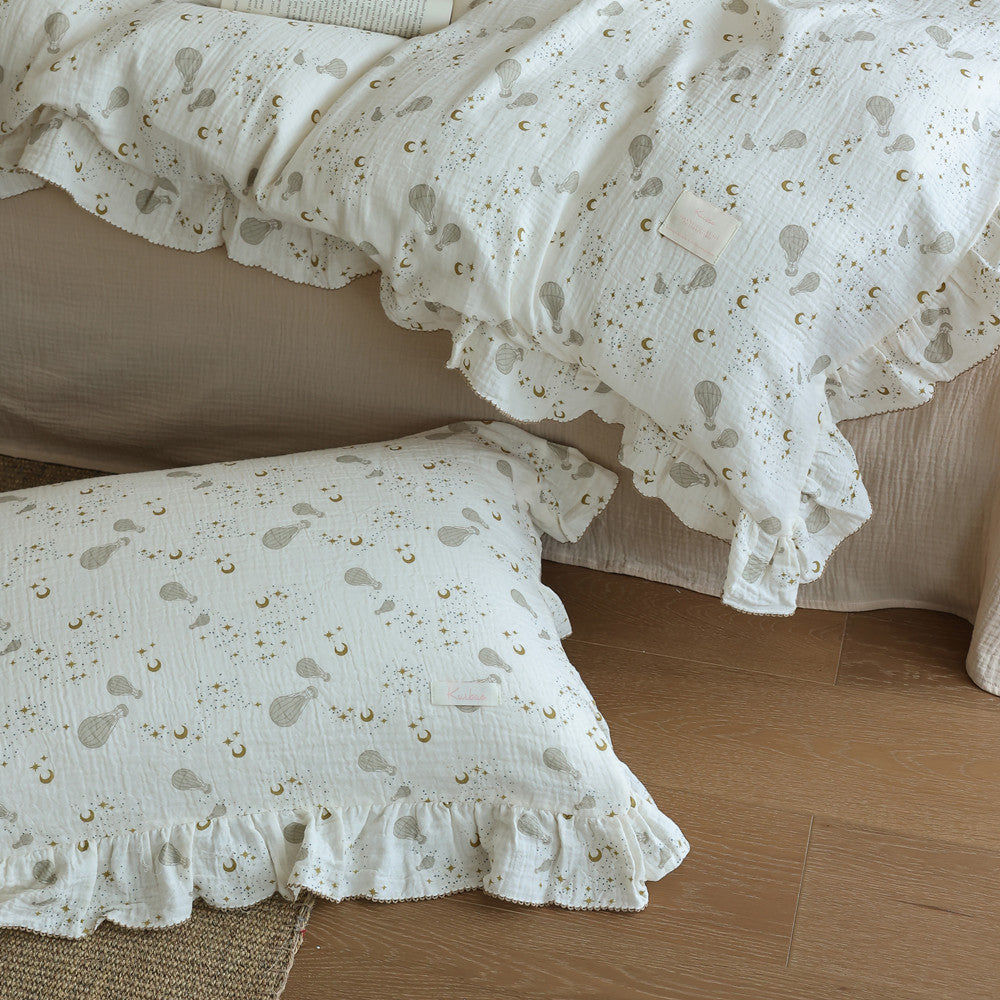 Close-up of the ruffle trim on a hot air balloon duvet cover and matching pillow sham. Shows the celestial print details.