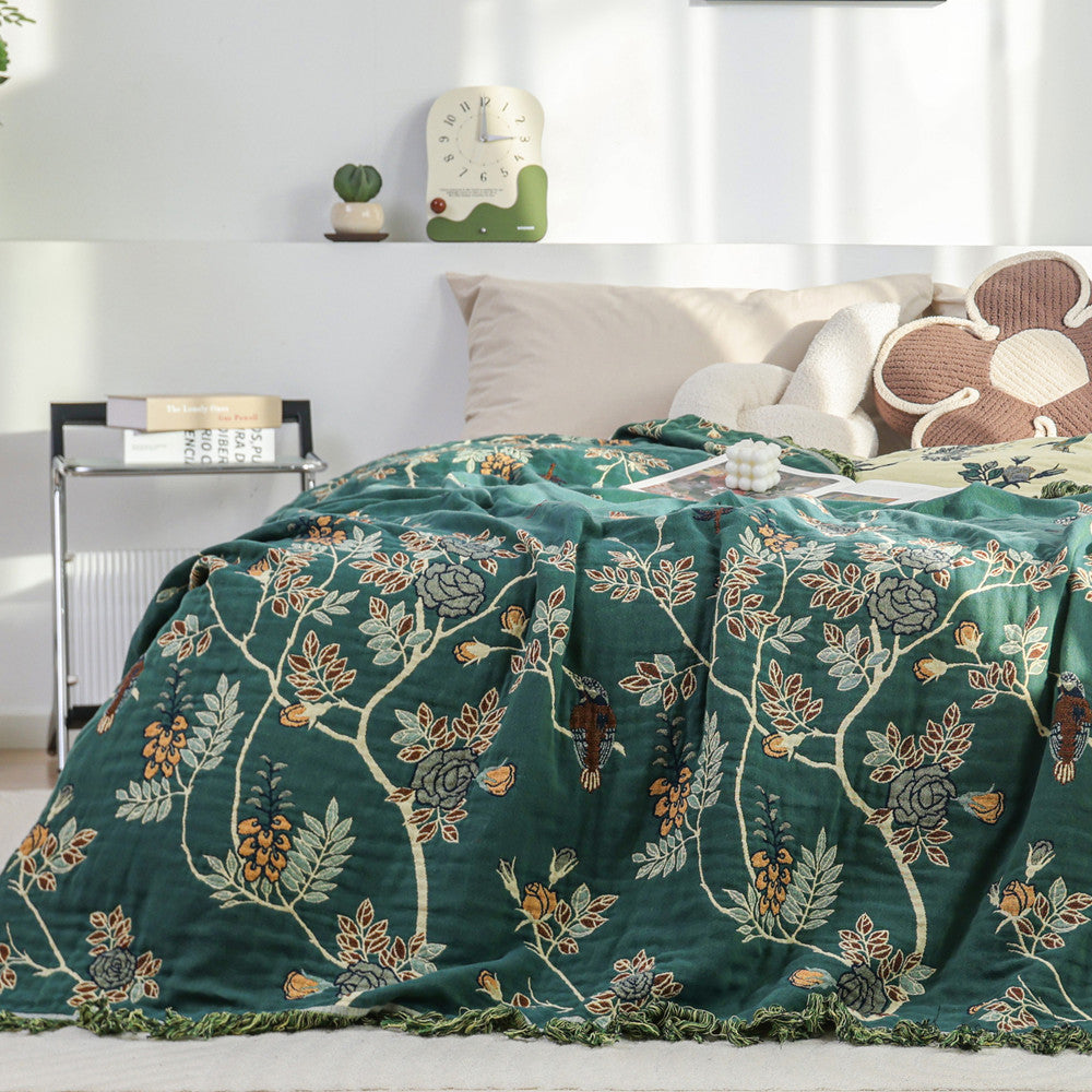 Reversible cotton jacquard blanket with botanical design on bed