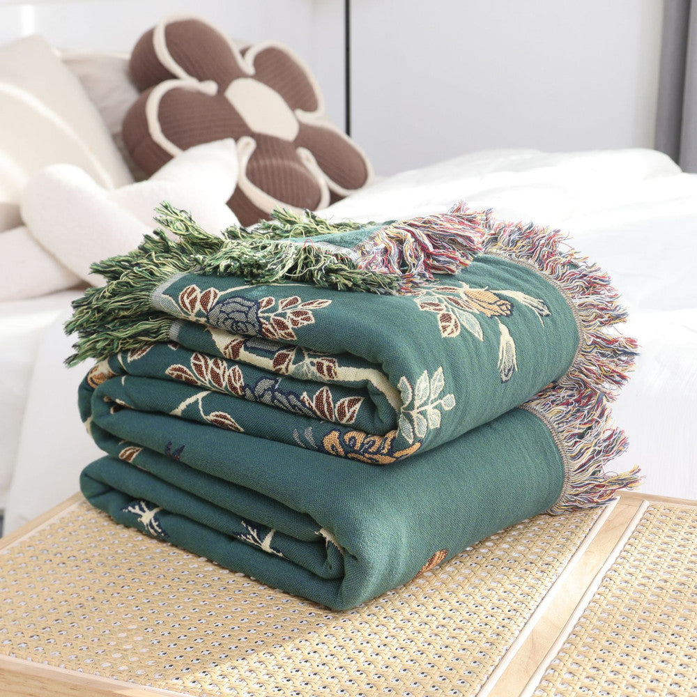 Folded green jacquard throw with floral fringe detail