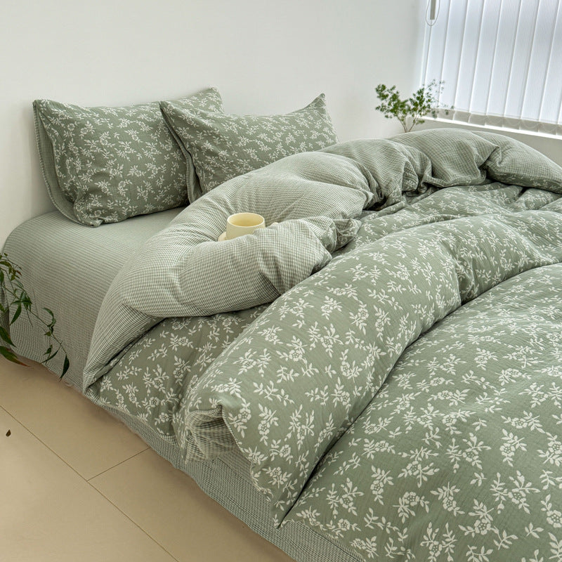 A side-angle photo of the green 100% Cotton Jacquard Duvet Cover Set to show the reversible gingham side and the Leaf Pattern.