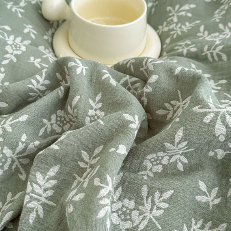 A close-up shot of the green 100% Cotton Jacquard Duvet Cover, focusing on the fabric texture and the white Leaf Pattern.
