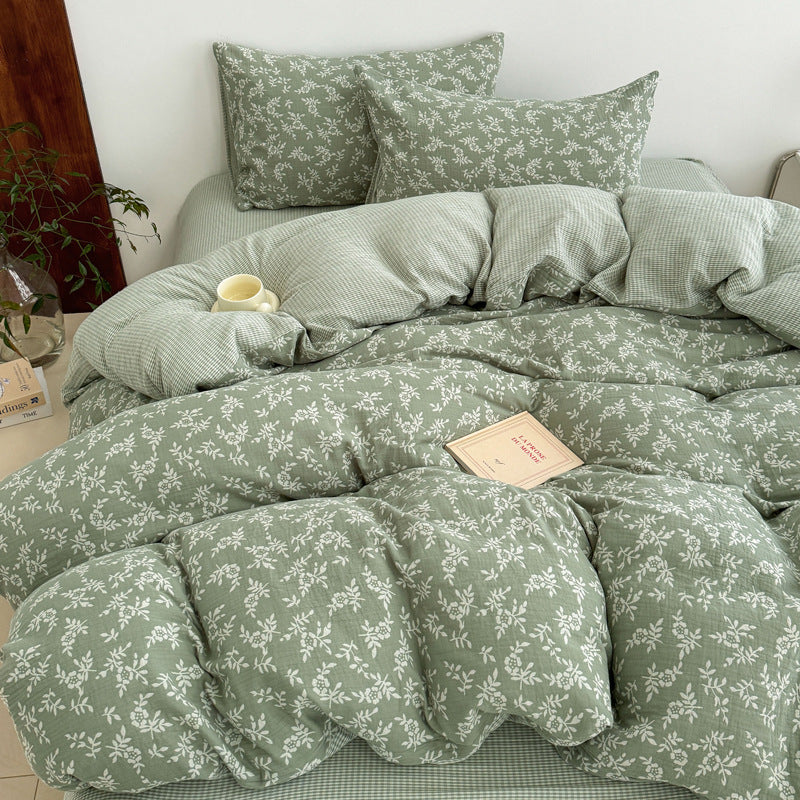 A close-up of a green 100% Cotton Jacquard Duvet Cover on a bed with a book, highlighting the soft texture and the Leaf Pattern.
