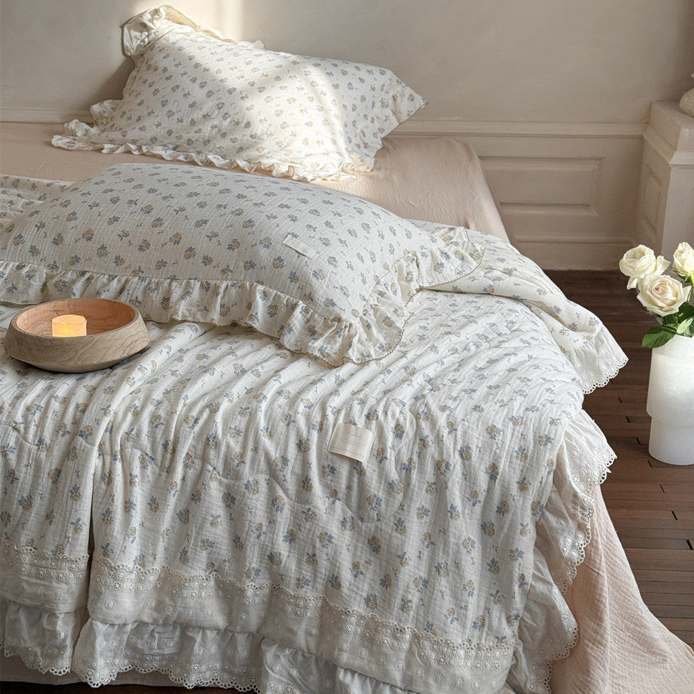 Lightweight cotton comforter folded on bed showing double ruffle layers