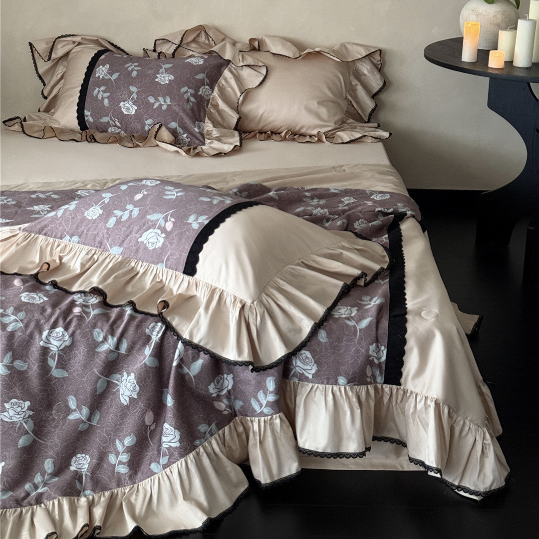 Dusty mauve floral comforter set with ruffled edges and soft luster