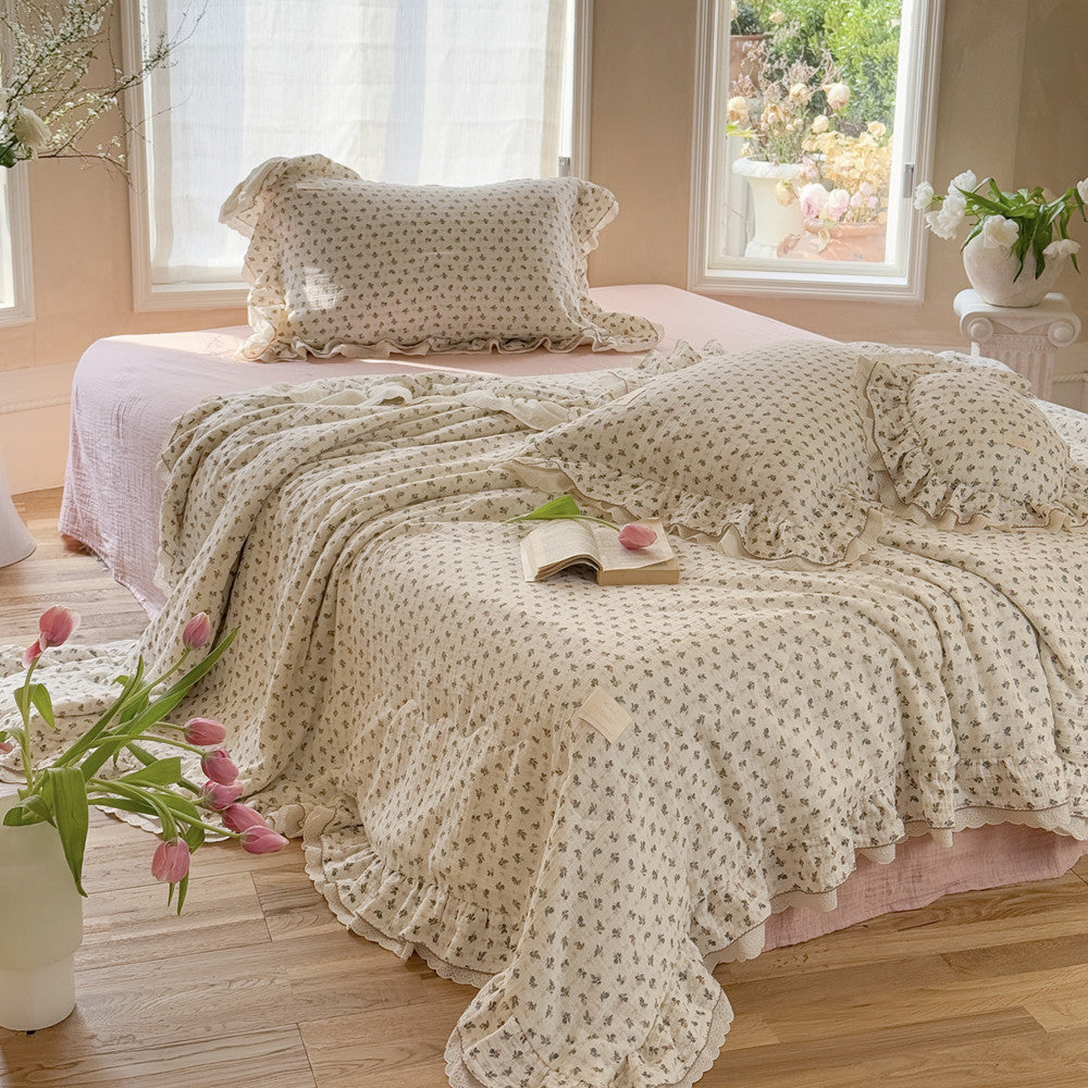 Gauze comforter with pink roses and ruffled edge on wooden floor