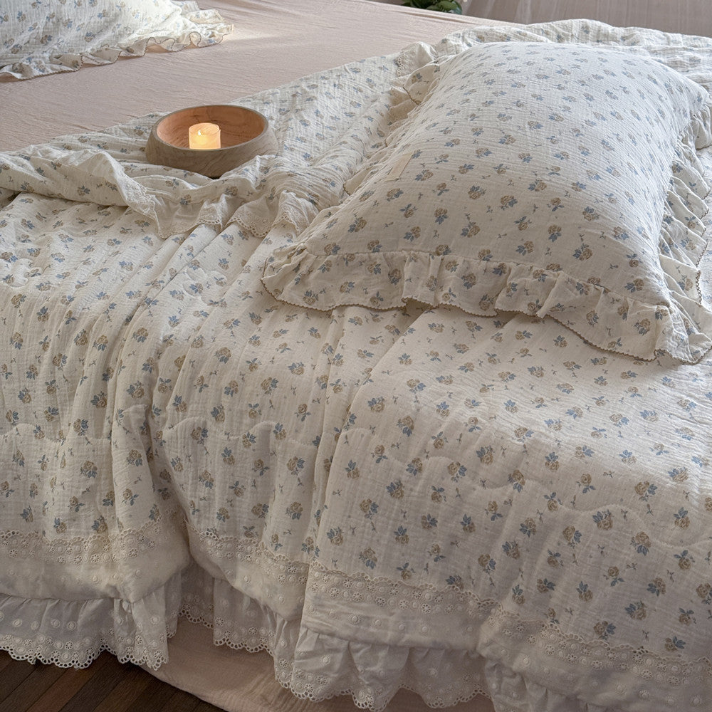 Ruffled rose floral quilt on queen-size bed with romantic styling