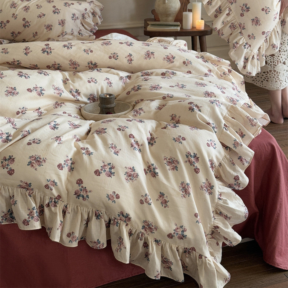 Detailed shot of the Vintage Rose Floral Bedding Set, highlighting the small, repeated rose pattern and the wide, cascading ruffles on the cotton duvet cover.