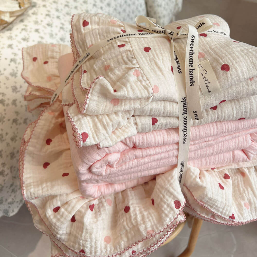 Stacked Girls Ruffle Duvet Cover Set in pink and cream heart print and solid color, tied with a decorative ribbon.