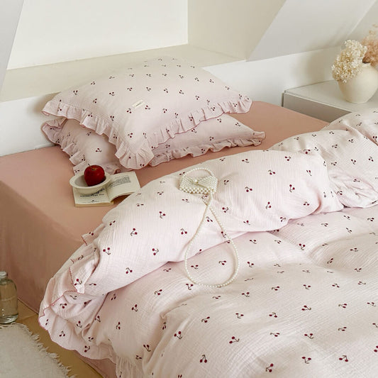 Top view of twin size cozy cherry print ruffle bedding set with pillows.
