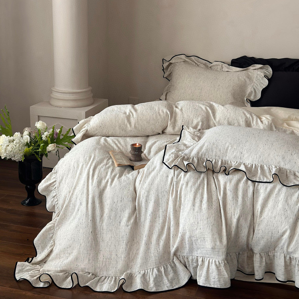 Bedside view of an elegant ruffle duvet set in shabby chic style, showcasing the black trimmed ruffles on the cotton duvet cover and shams.