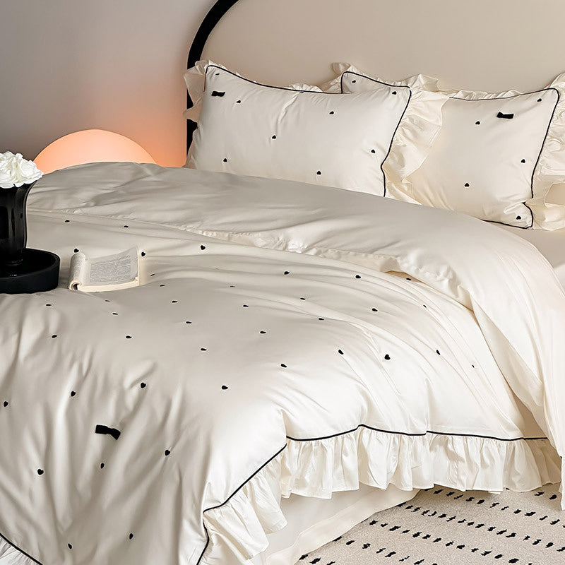Side view of ivory duvet and pillowcases with ruffle edge