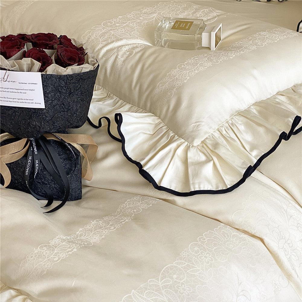Overhead detail of the silky bedding set with ruffles in cream white, highlighting the delicate lace pattern and a bouquet of red roses.