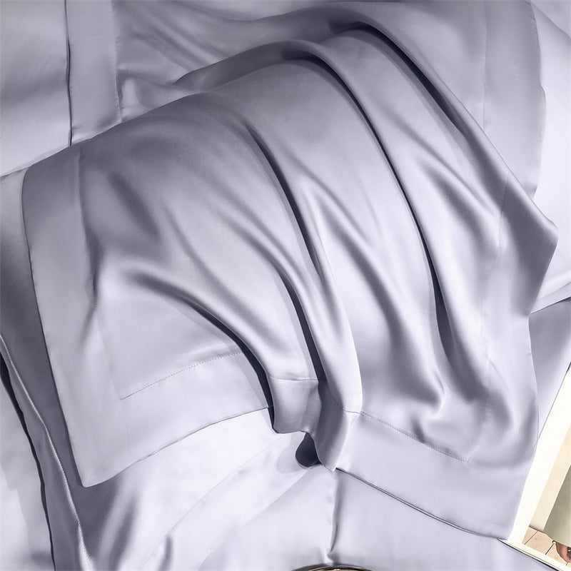 Silky light gray Tencel Lyocell cooling pillowcase on a bed, luxury sustainable bedding from StuffedHome