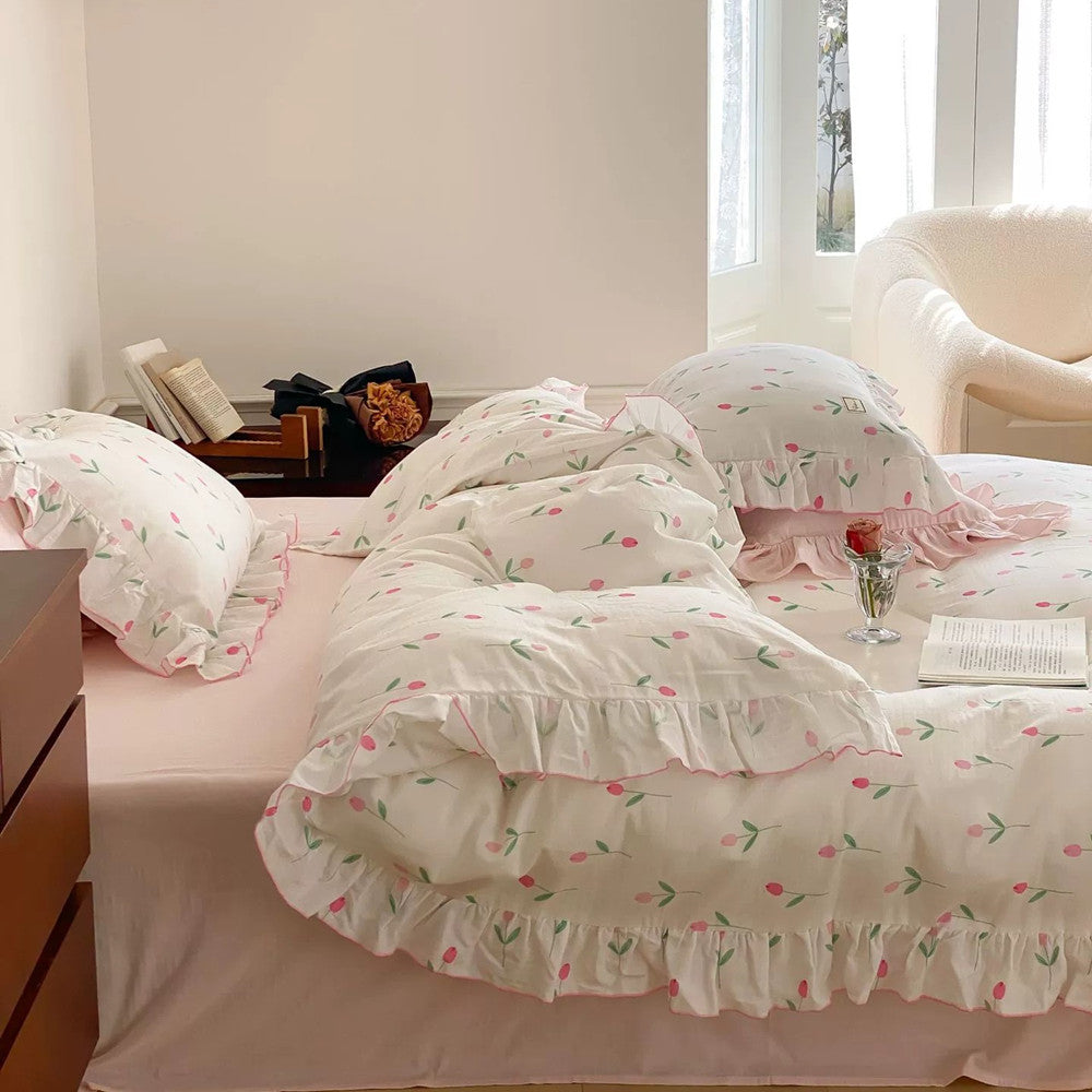 Full bed view of the Pink Tulip Bedding Set, highlighting the ruffled cotton floral bedding with white and pink colors in a sunlit bedroom.