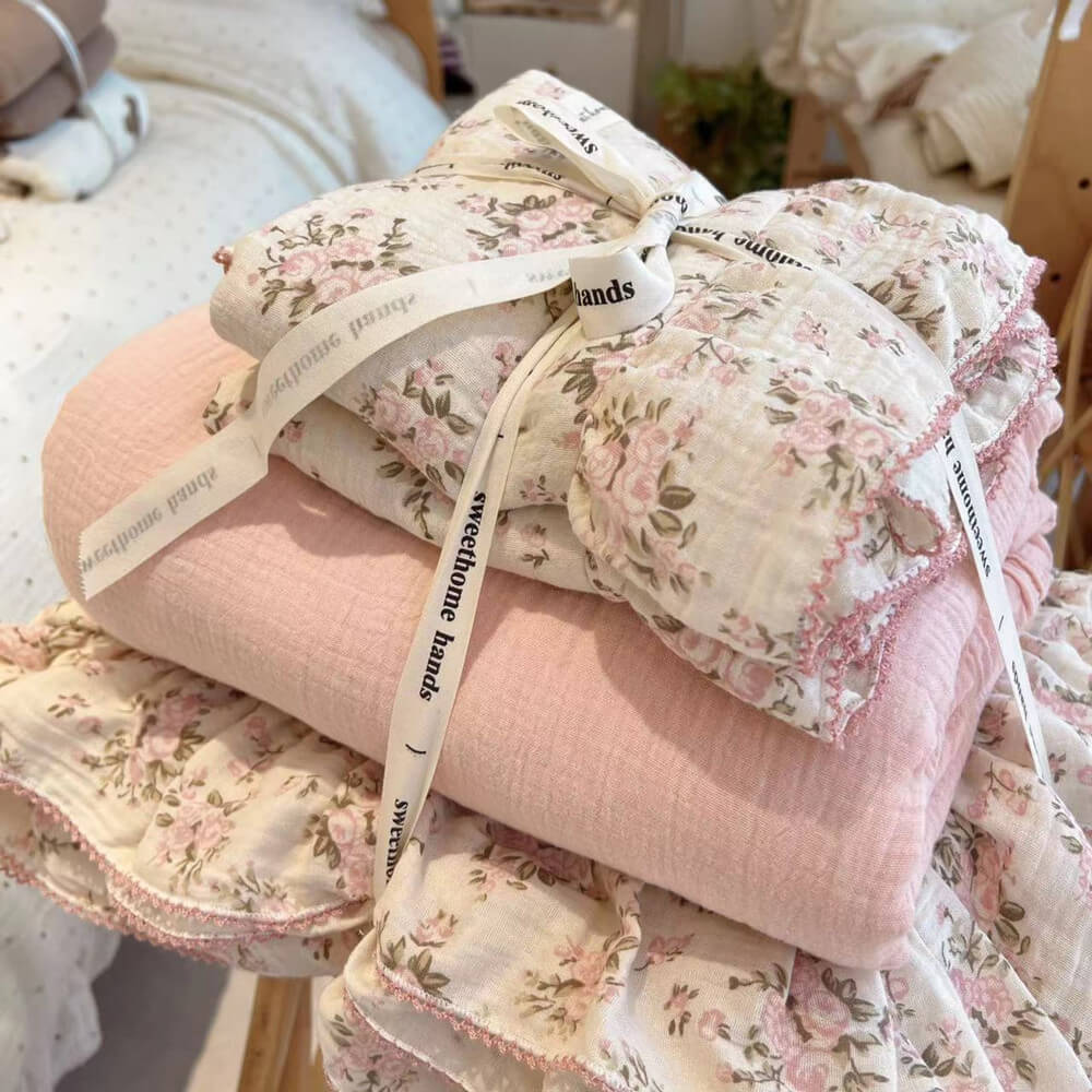 Folded Pink Floral and Solid Pink Double Gauze Bedding Set tied with a ribbon, showcasing both the floral duvet cover and the matching solid color pink cotton sheet or blanket for a complete bedding collection.
