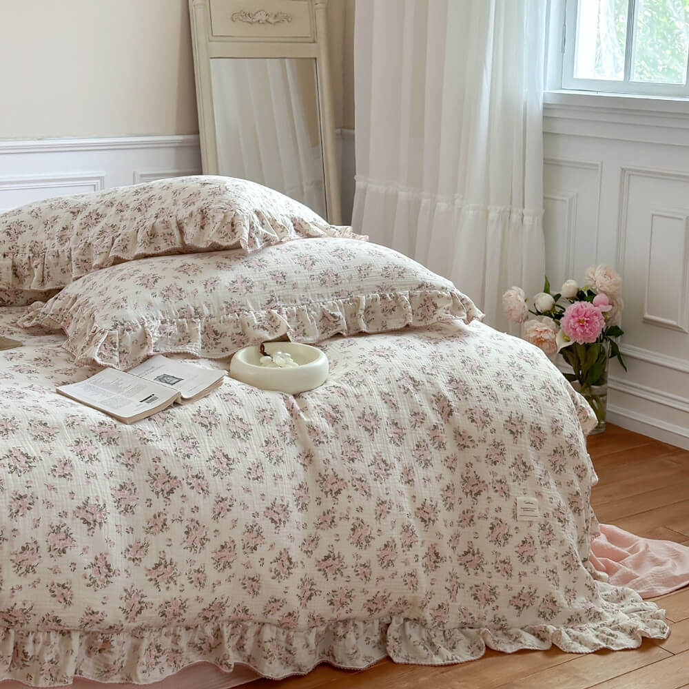 Close-up of the Ruffled Pink Floral Cotton Gauze Bedding Set showing the soft texture of the muslin fabric and the delicate ruffle trim on the duvet and pillow shams, perfect for a romantic bedroom.