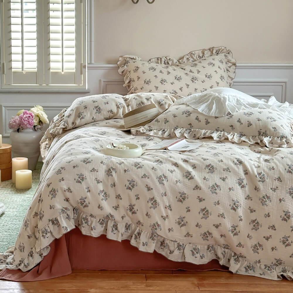 floral cotton muslin duvet cover with ruffle edge on a bed, with rust flat sheet and matching ruffled pillowcase