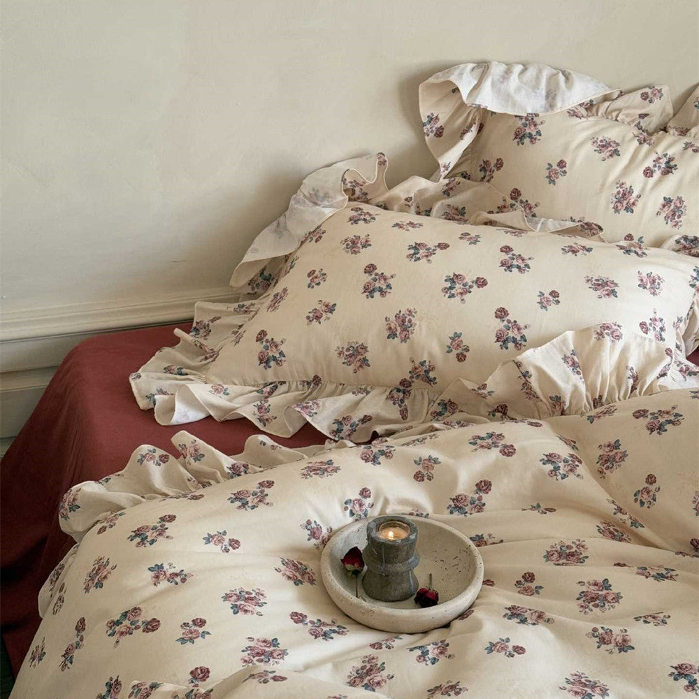 Close-up of pillows and duvet from the Vintage Rose Floral Bedding Set, emphasizing the delicate floral print and the soft ruffle edge on the cotton fabric.