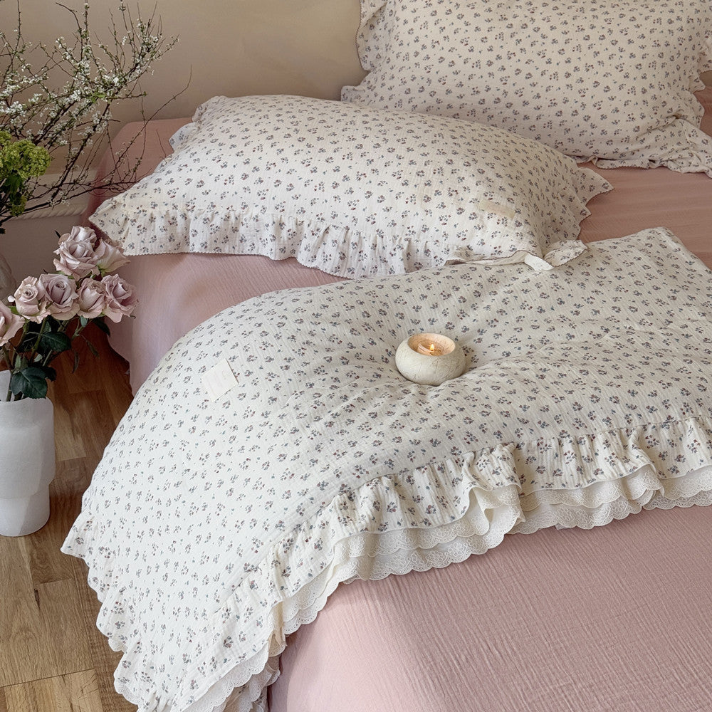 French vintage bedding featuring lace-trimmed comforter and candle detail on a pink bed