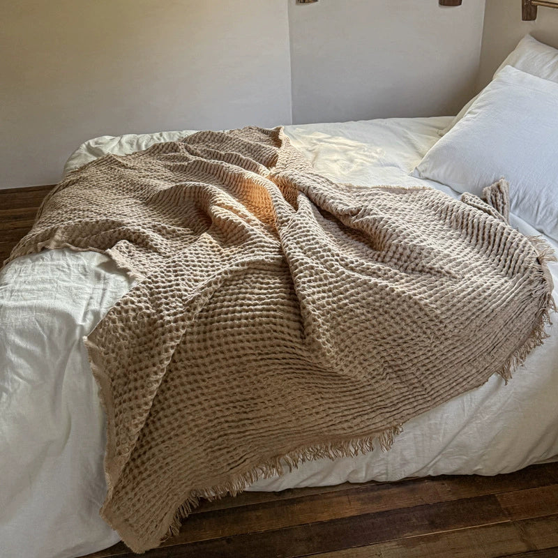 Light brown waffle throw blanket casually styled on bed