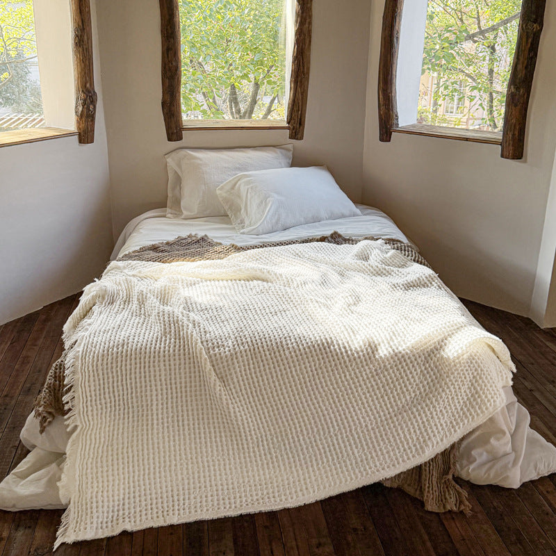 Cream waffle weave fringe throw blanket styled on bed