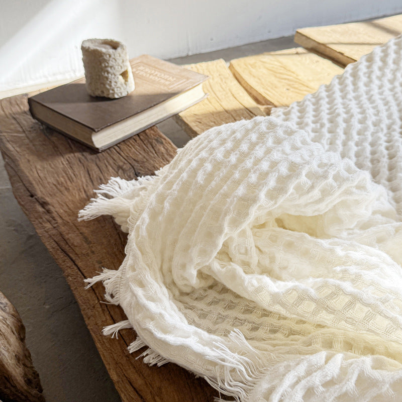 white waffle weave throw with fringe on the table