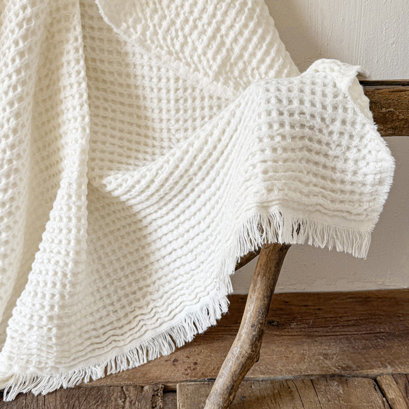 Fringe edge of white waffle weave throw blanket