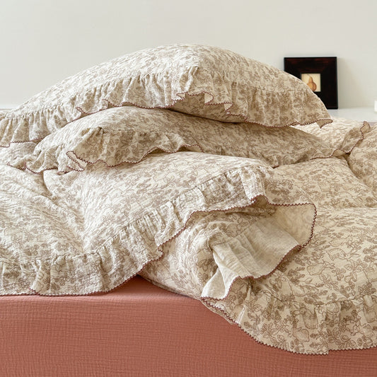 A beige bedding set with a woodland theme, including a duvet cover, flat sheet, and pillowcases, displayed on a bed.