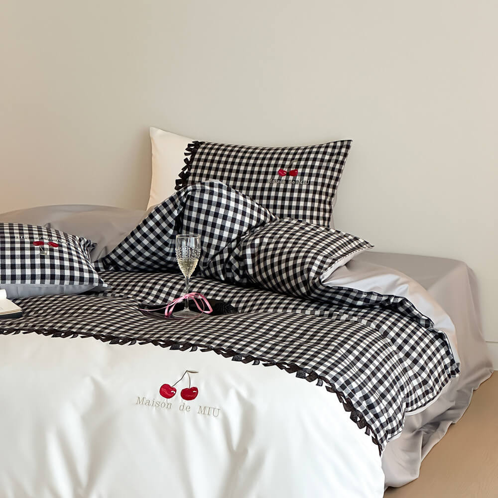 Luxury black and white gingham cotton bedding set with cherry embroidery on bed in minimalist room