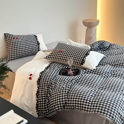 Black and white gingham cotton bedding set with matching pillows on a modern bed, natural wood stool and soft lighting