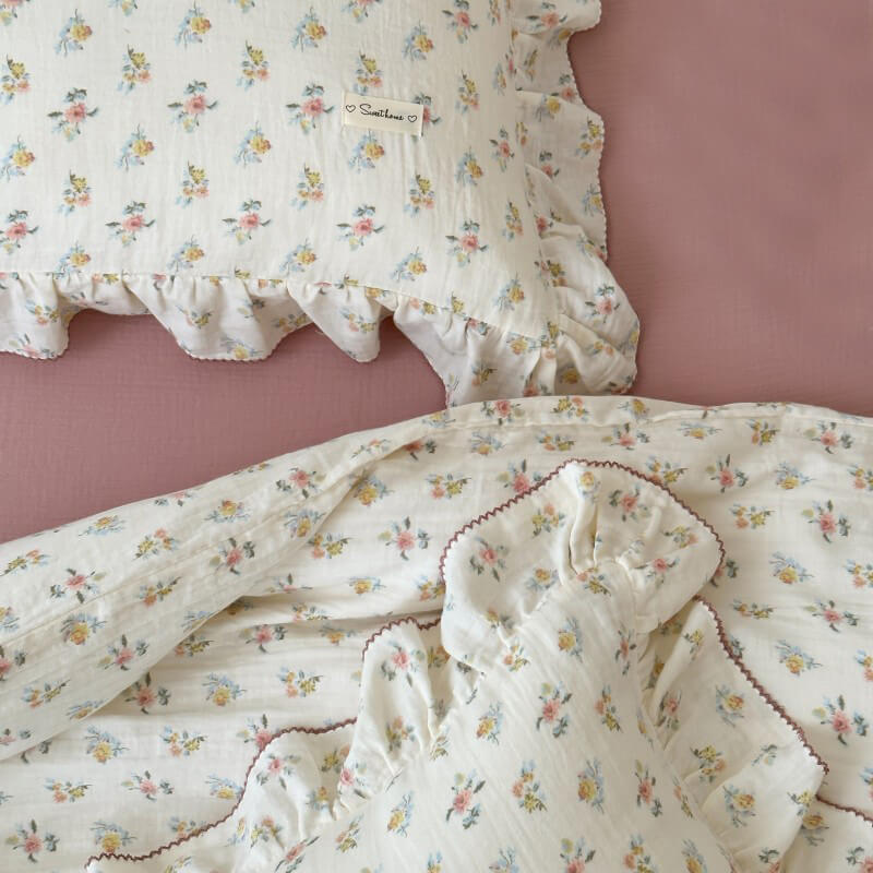 Floral-patterned bedding with ruffled edges on a pink background