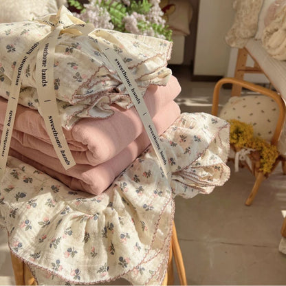Folded Bellflower Floral Cotton Gauze Bedding Set tied with a ribbon, showcasing the floral pattern and a coordinating solid pink cotton sheet, presented as a premium, gift-ready bedding package.