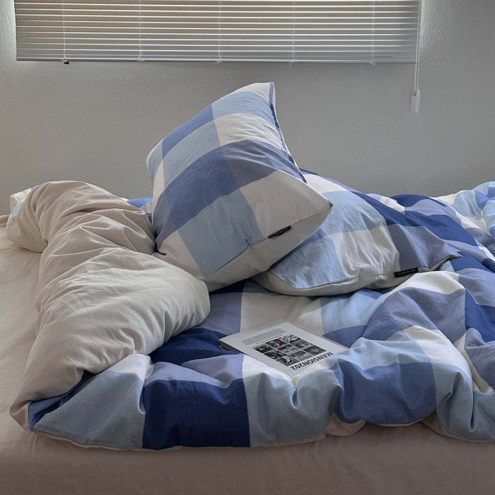 Blue plaid cotton bedding set with matching pillows on a cozy bed in natural light