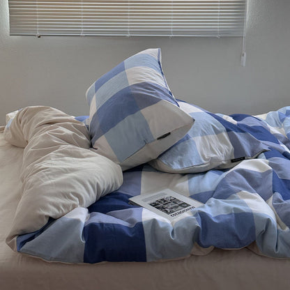 Blue plaid cotton bedding set with matching pillows on a cozy bed in natural light