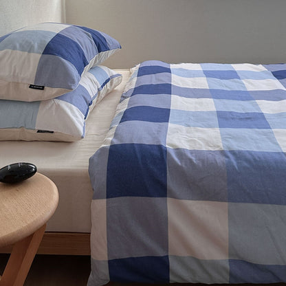 Blue plaid cotton bedding set with pillowcases on a modern bed