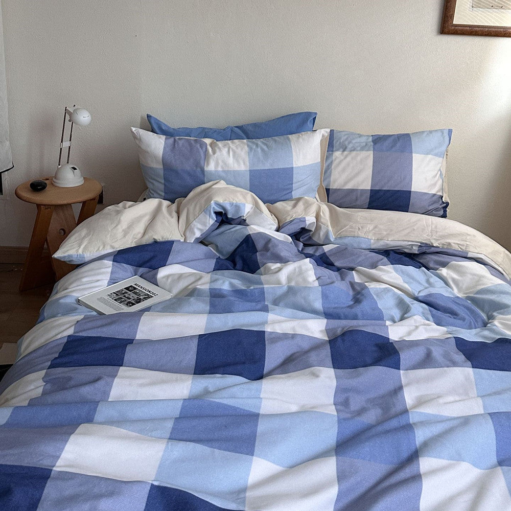 Blue and white plaid cotton bedding set on a cozy, modern bed with pillows