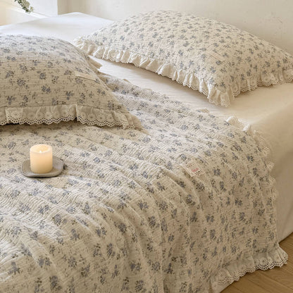 Overhead detail of blue rose cotton comforter with ruffled lace trim and crinkled texture