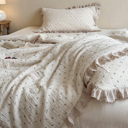 Breathable crinkled cotton gauze summer blanket with a tiny blueberry and leaf print, showcasing elegant eyelet lace ruffled edges on a vintage cottage style bed.