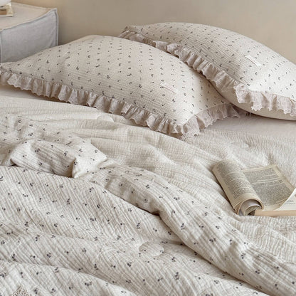 A pair of vintage aesthetic blueberry pattern ruffled pillowcases with lace borders, layered on a cream-colored bed with an open book for a dreamy aesthetic.