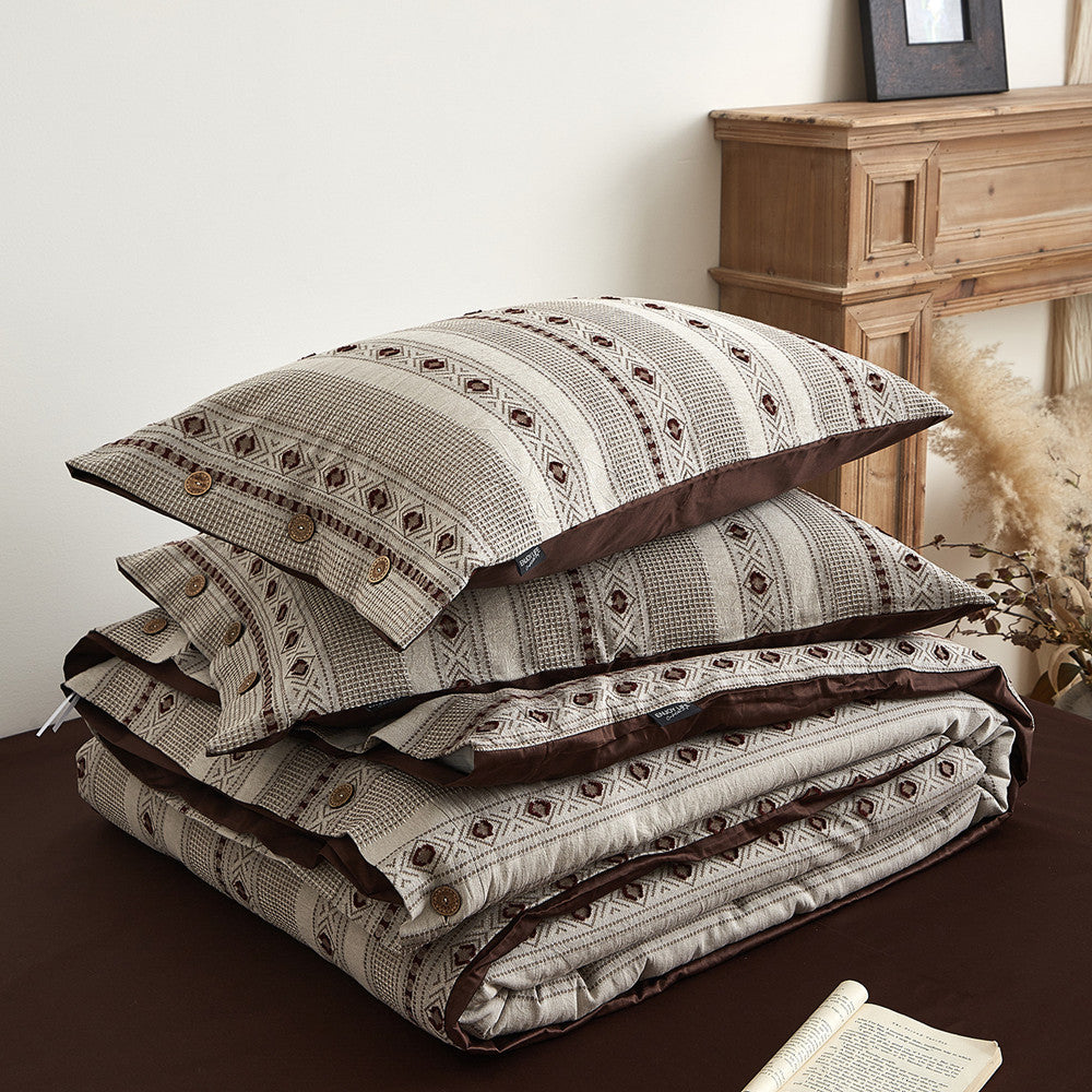 Boho cotton jacquard bedding set with geometric pattern, matching pillows, and duvet on bed.