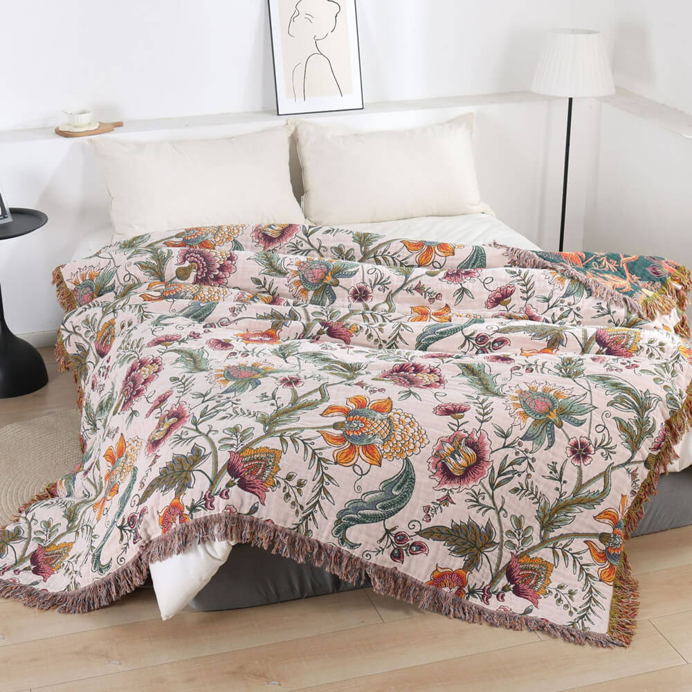 Boho floral cotton throw blanket with fringe styled on a bed