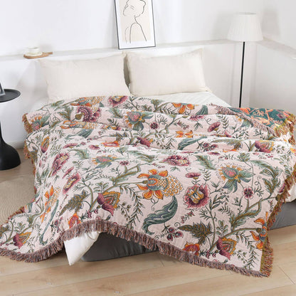 Boho floral cotton throw blanket with fringe styled on a bed