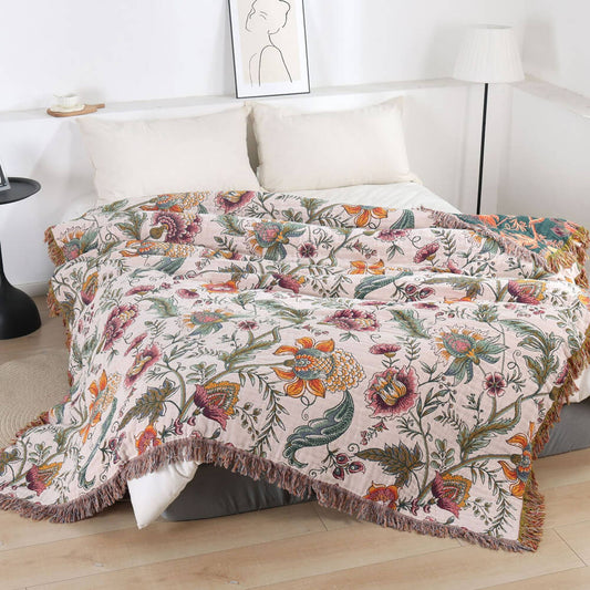 Boho floral cotton throw blanket with fringe styled on a bed