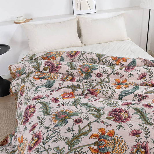 Blush beige boho floral cotton throw blanket with vine pattern on a bed