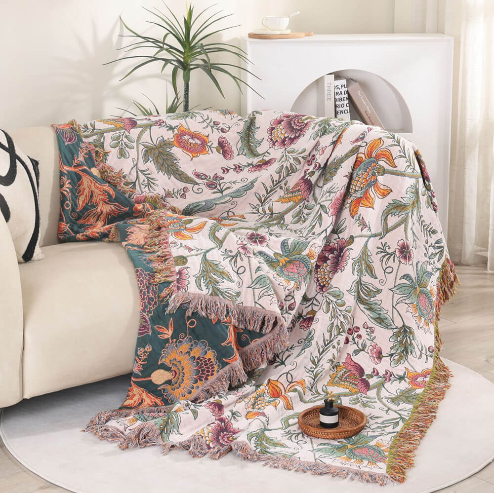 Boho floral cotton throw blanket draped over a sofa showing deep teal reverse side